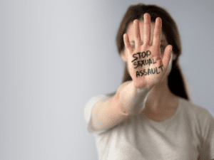 Woman holding up hand with words Stop Sexual Assault